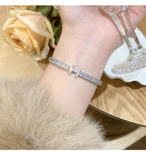 Close-up of a silver pavé bracelet with rectangular zircon crystals on a model's wrist