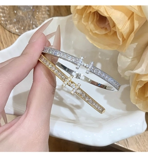 Macro shot of gold and silver H-letter bracelets encrusted with sparkling cubic zirconia