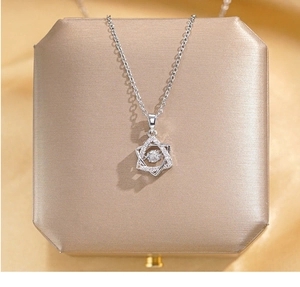 Detail of silver hexagram star pendant with zircon on champagne satin jewelry box