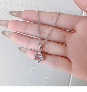 Macro shot of silver hexagon pendant with sparkling dancing stone and pavé accents