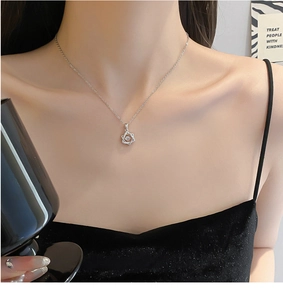 Detail view of hexagram pendant with dancing stone on silver chain worn by model