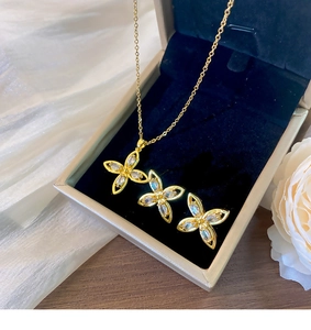 Details des goldenen Blumenschmucksets mit Zirkon-Blütenblättern in einer Geschenkbox