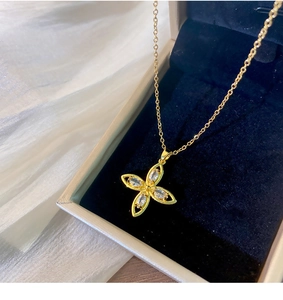 Makroaufnahme einer goldenen Blumenhalskette mit Zirkonia in einer edlen Geschenkbox