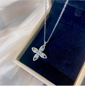 Makroaufnahme von Silber-Blumenanhänger mit Marquise-Steinen auf dunkelblauem Samtgrund