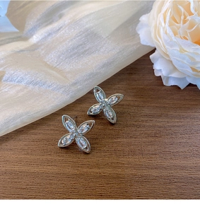 Edle silberne Blumenstecker mit Zirkonia im Marquise-Schliff auf Seidenhintergrund