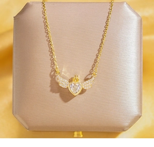 Détail du pendentif cœur couronne en plaqué or avec ailes d'ange et zircons
