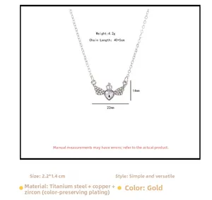 Gros plan du collier cœur ailes d'ange et couronne plaqué or avec détails en zircon