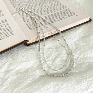 Dettaglio della collana a doppio strato in acciaio al titanio con perle geometriche