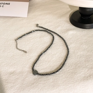Dettaglio della collana di perline di ematite grigio scuro con ciondolo esagonale