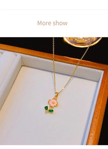 Dettaglio del ciondolo a fiore rosa con gemme verdi su catena in oro 18 carati
