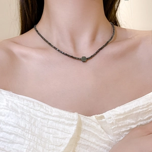 Dettaglio della collana in acciaio al titanio argentato con ematite nera su modella