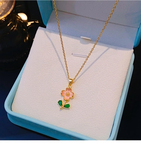Dettaglio della collana placcata oro 18k con fiore in smalto rosa e foglie di zircone verde