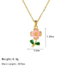 Dettaglio del ciondolo a fiore in smalto rosa con foglie di cristallo verde e catena d'oro