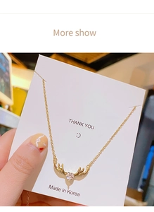 Detalle del collar de asta de ciervo dorado con colgante de circón rosa de corazón