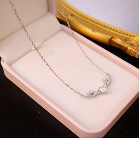 Detalle del colgante de asta con circón de corazón en una caja de regalo rosa