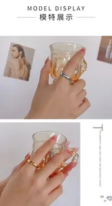 Bagues minimalistes polies en or et argent portées au doigt avec texture lisse