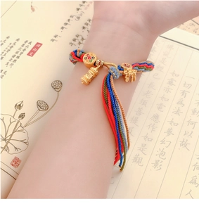 Hand-woven Tibetan bracelet with colorful silk threads and a golden Gawu box pendant