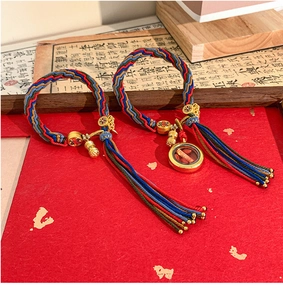 Detail of handmade woven bracelets with mini prayer wheel charms and vibrant tassels