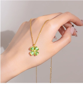 Dettaglio della collana a quadrifoglio dorata con pietra occhio di gatto verde e diamante