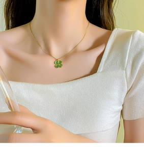 Primo piano della collana a quadrifoglio dorata con opale verde indossata dal modello