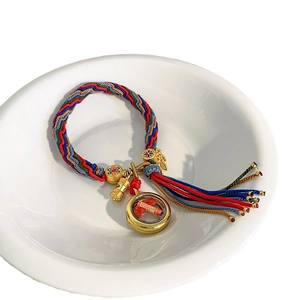 Handwoven Tibetan style bracelet with golden gau box pendant and colorful silk tassels