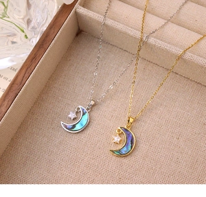 Détail des colliers étoile et lune avec incrustation d'abalone dans un coffret