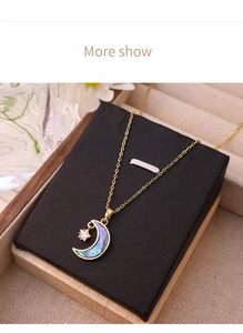 Détail du pendentif étoile et lune avec incrustation d'abalone irisée sur chaîne dorée