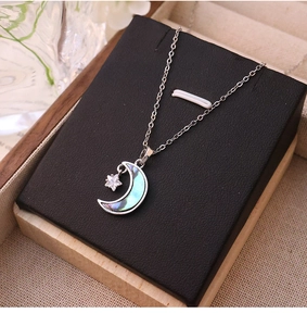 Détail du collier pendentif lune et étoile avec incrustation en nacre irisée