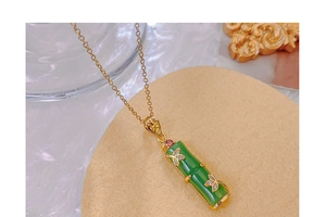 Close-up of bamboo pendant necklace with green jade imitation and 18k gold details