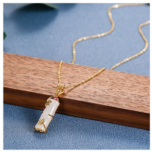 Detail of bamboo joint pendant with white faux jade and 18k gold plating on steel chain
