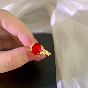 Lujoso anillo bañado en oro con un gran circón rojo óvalo y acentos laterales