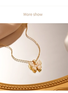 Detail of golden butterfly necklace with white shell inlay and zircon on mirror surface