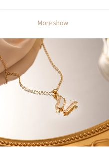 Macro detail of butterfly pendant necklace with zircon and shell inlay on silk surface