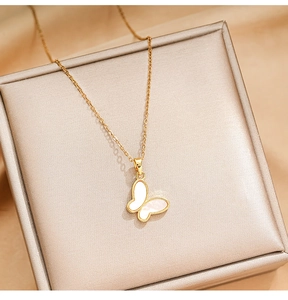 Close-up of golden butterfly necklace with white shell inlay on a satin jewelry box