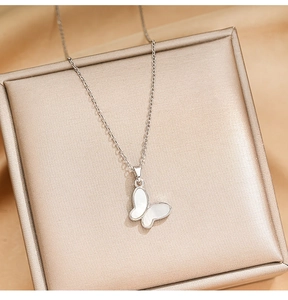 Detailed view of zircon butterfly pendant necklace on a luxury champagne silk gift box
