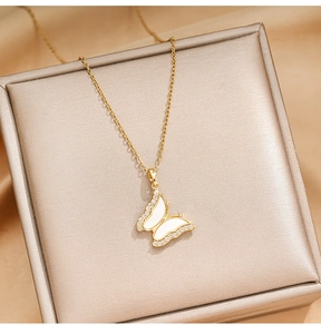 Detail of gold butterfly necklace with white shell inlay and sparkling cubic zirconia stones