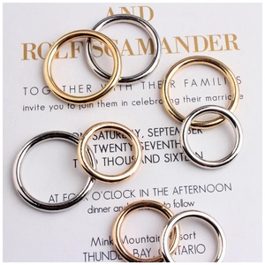 Anelli circolari geometrici minimalisti in oro e argento su elegante carta da matrimonio