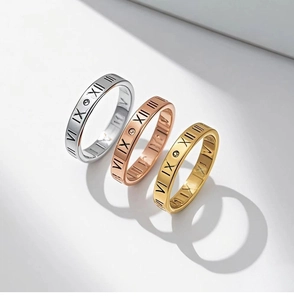 Detailed close-up of roman numeral engraved steel rings in gold, silver and rose gold