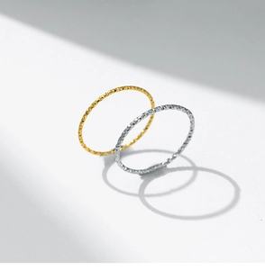 Detalle de anillos de 1 mm texturizados en oro y plata con motivos de corte diamante