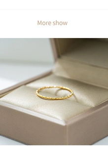 Vista detallada de anillo de titanio dorado de 1mm con corte de diamante en caja de joyería