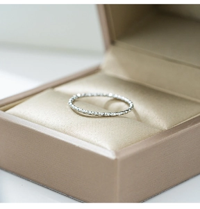 Primer plano de un anillo de plata de 1mm con corte de diamante en caja de regalo
