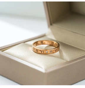 Macro shot of rose gold roman numerals ring with sparkling zircon in a luxury jewelry box