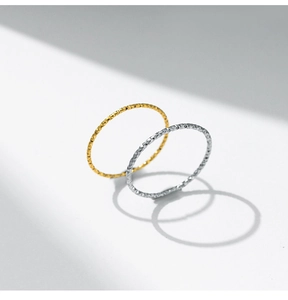 Primer plano de anillos finos dorados y plateados con acabado de textura martillada