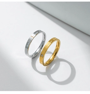 Macro detail of silver and gold rings with Forever love engraving and heart crystal