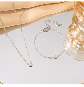 Close-up of S925 silver necklace and bracelet set with single zircon and hallmarked tag