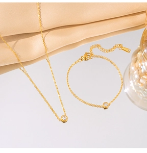 Close-up of minimalist titanium steel necklace and bracelet set with single round zircon