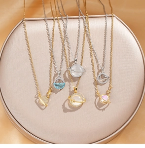 Detail showing various planet-themed necklaces with opal pendants on a beige display