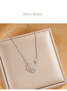 Detail of silver planet pendant necklace with zircon pavé on a luxury jewelry box