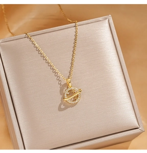 Close-up of golden Saturn pendant with sparkling zircons on a luxury gift box