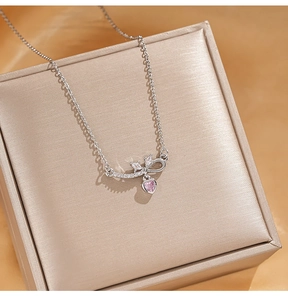 Detail shot of heart-shaped pink zircon pendant on silver chain on jewelry box